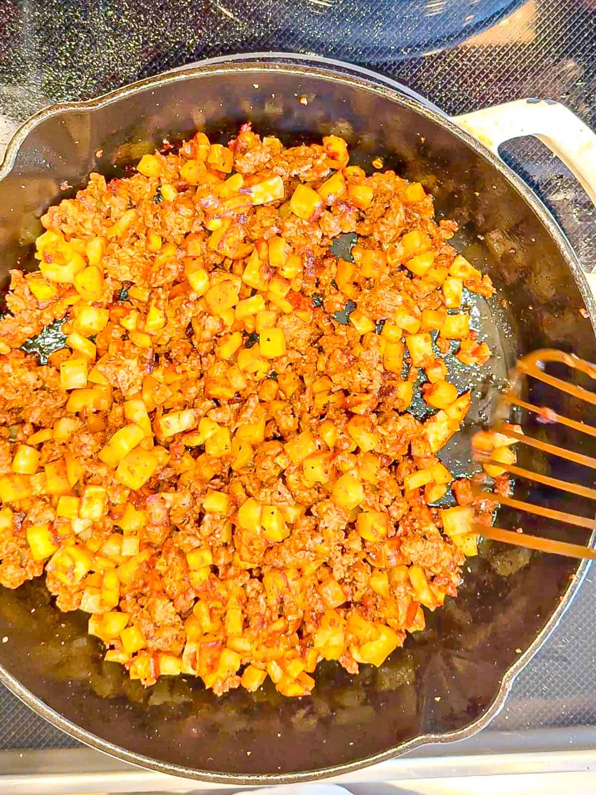 Cooking chorizo and potatoes in a cast-iron pan.