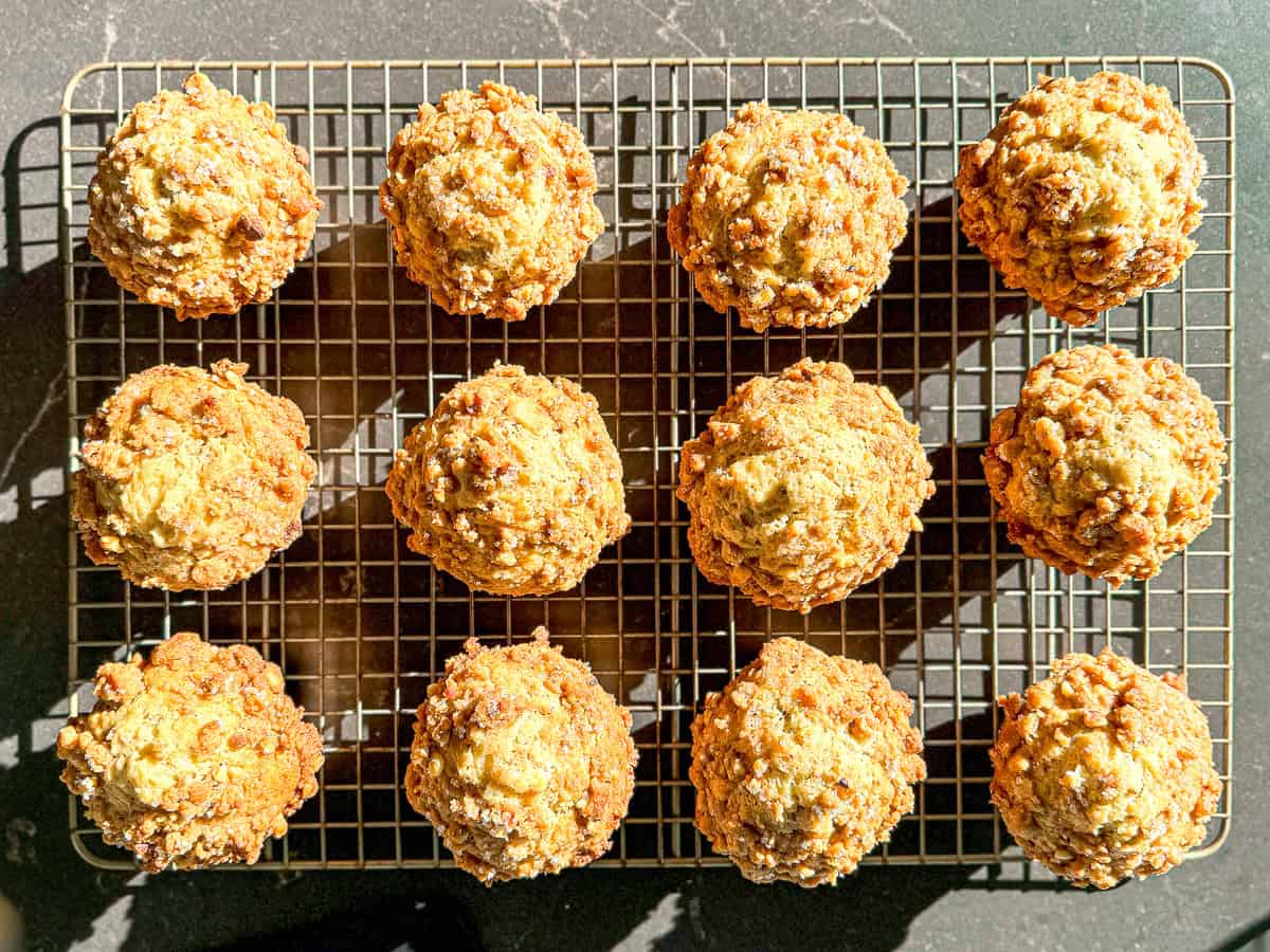 Pistachio streusel muffins on a wire rack.