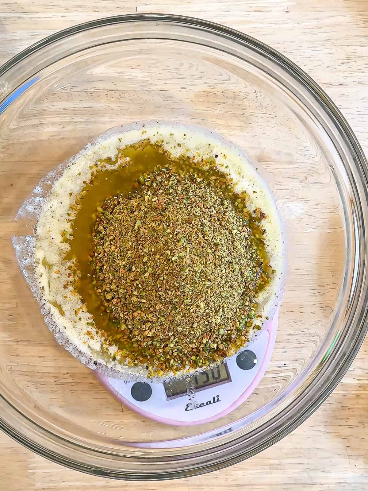 Brown butter and crushed pistachios in a glass bowl.