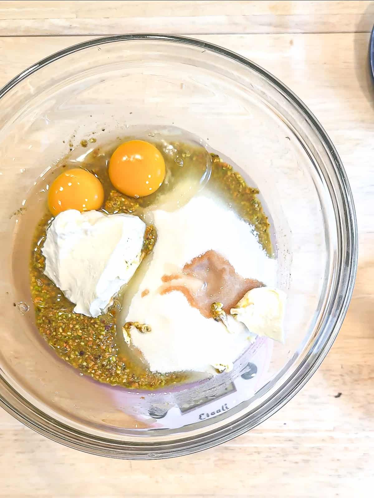 Wet ingredients to make pistachio muffins in a glass bowl.