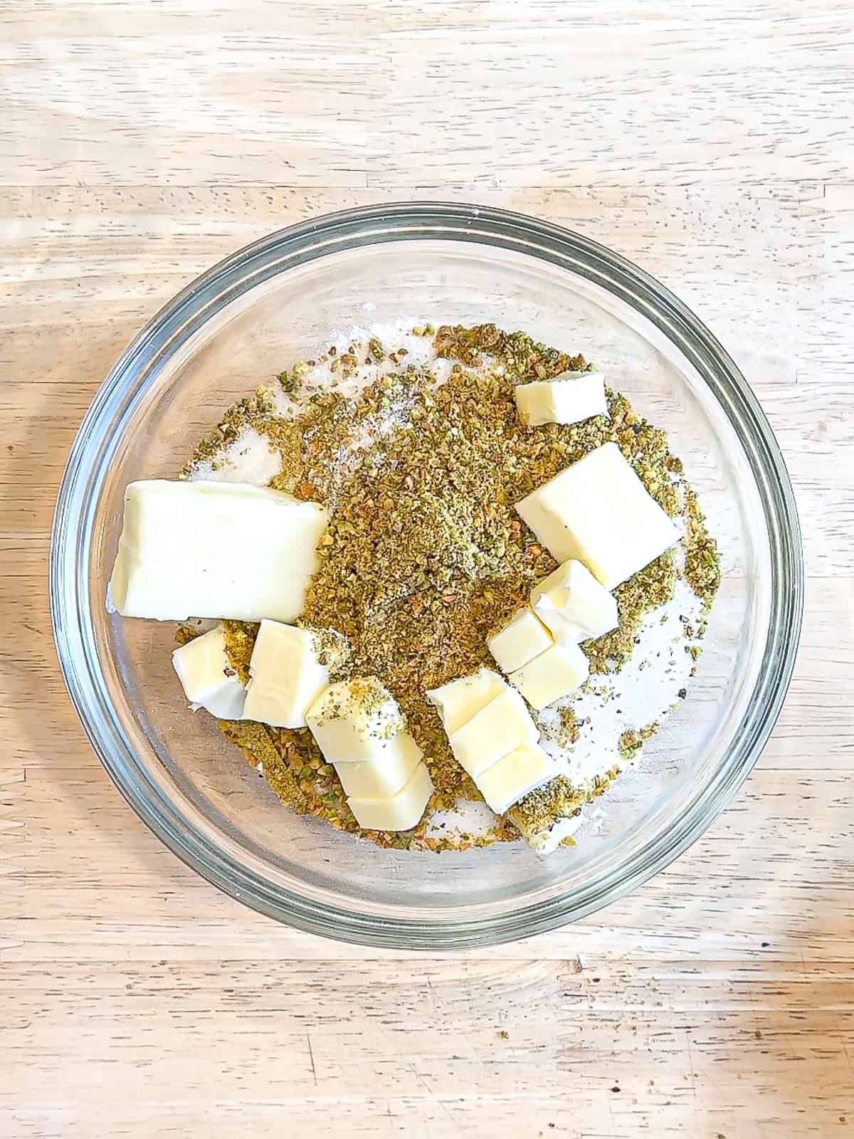 Ingredients for pistachio streusel in a glass bowl.
