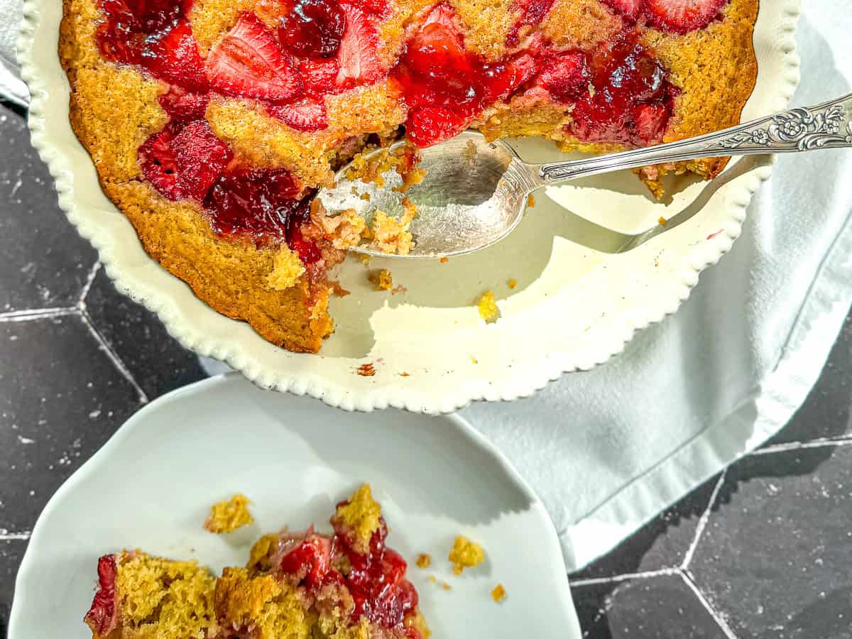 Spooning cake onto a white plate.