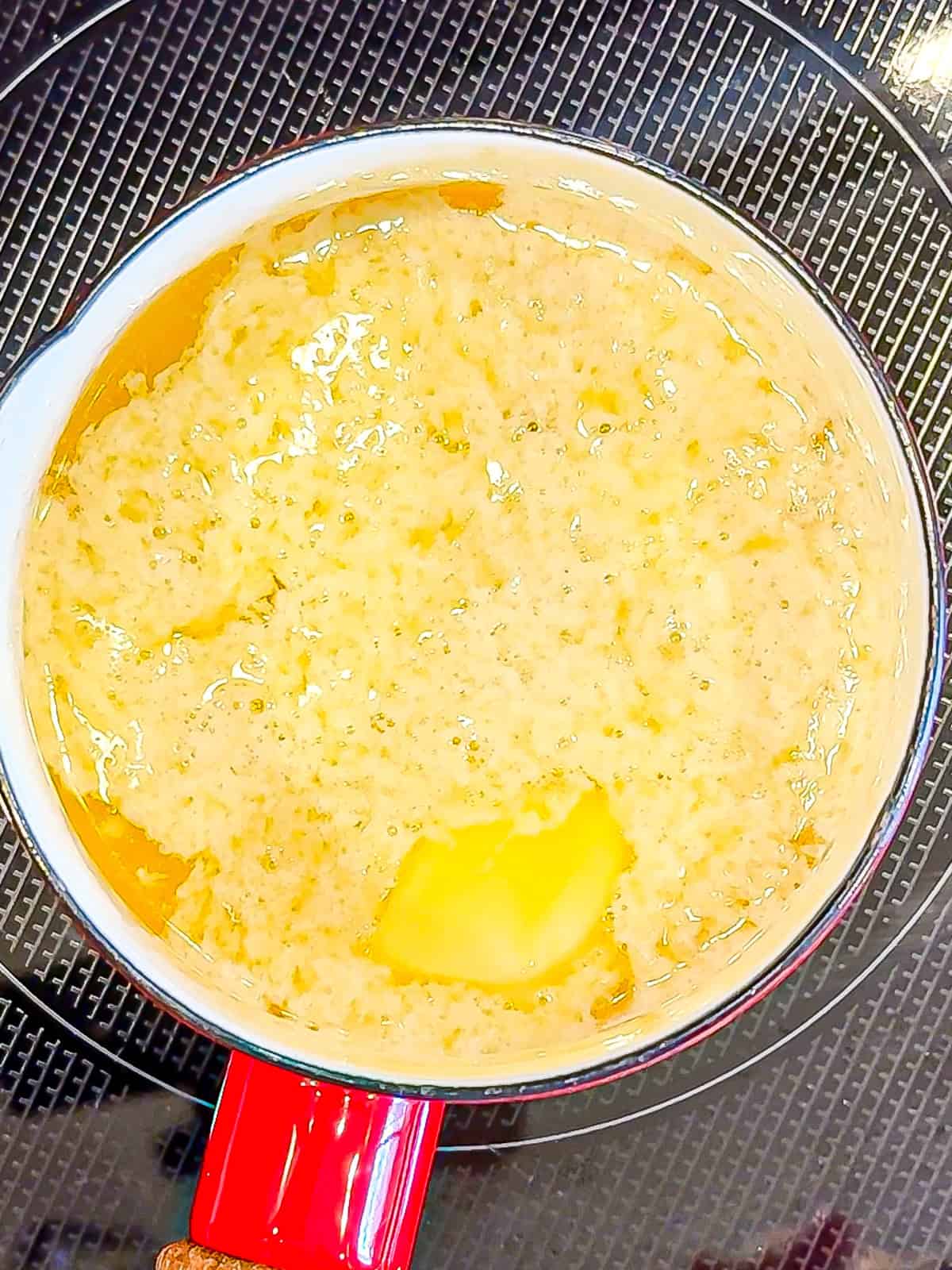 Melted butter in a red saucepan.