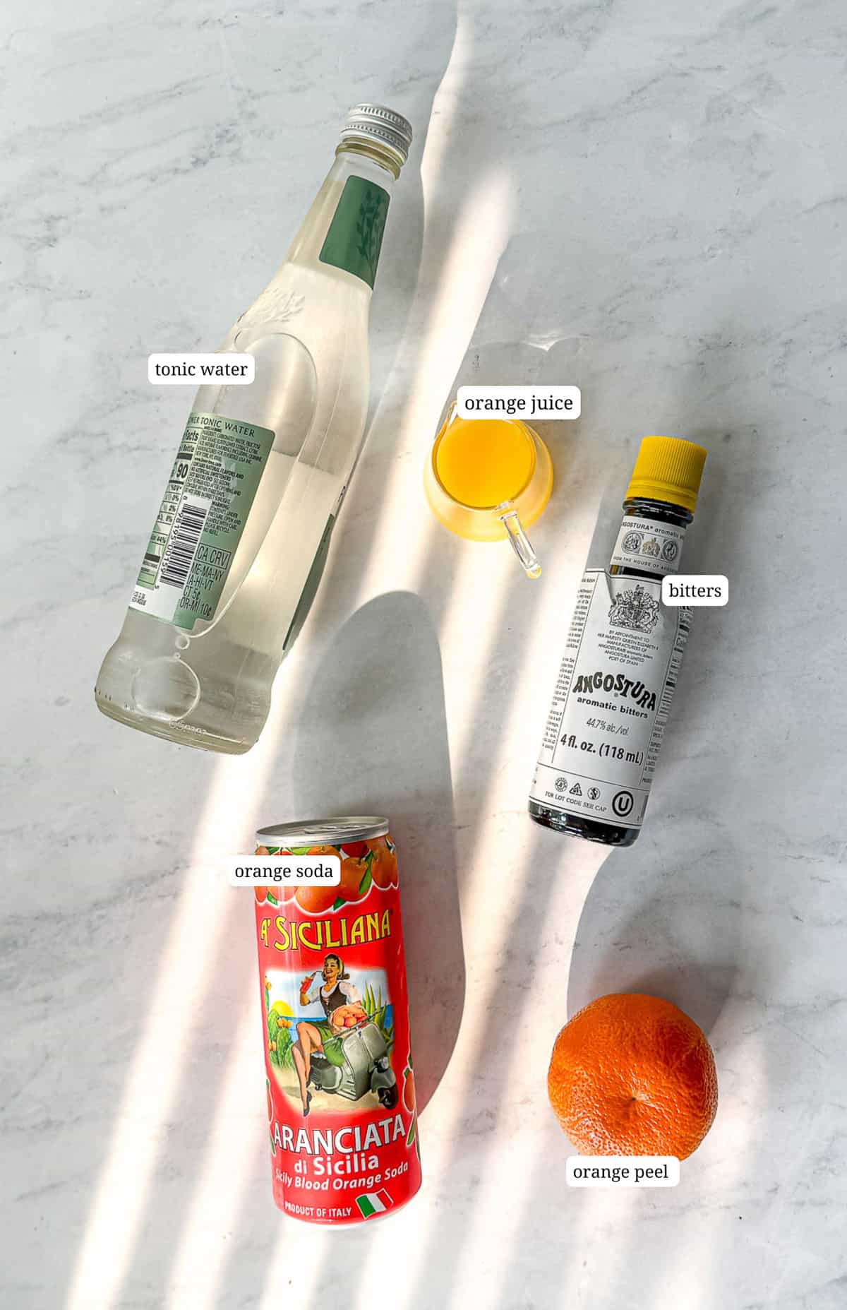 Ingredients needed to make aperol spritz mocktail.