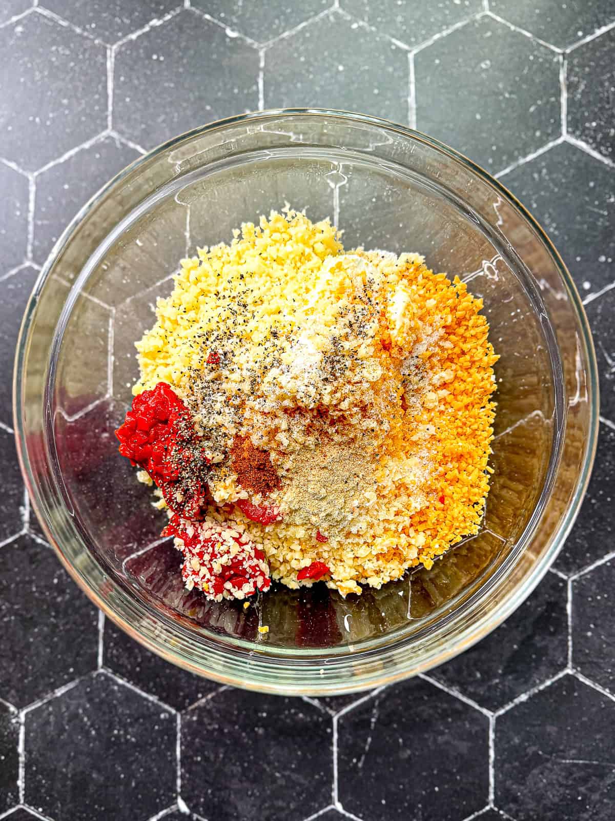 Ingredients for pimento cheese in a glass bowl ready to be mixed.