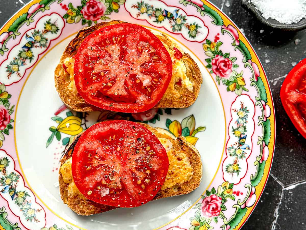 Pimento cheese melted on toast with tomatoes on top.