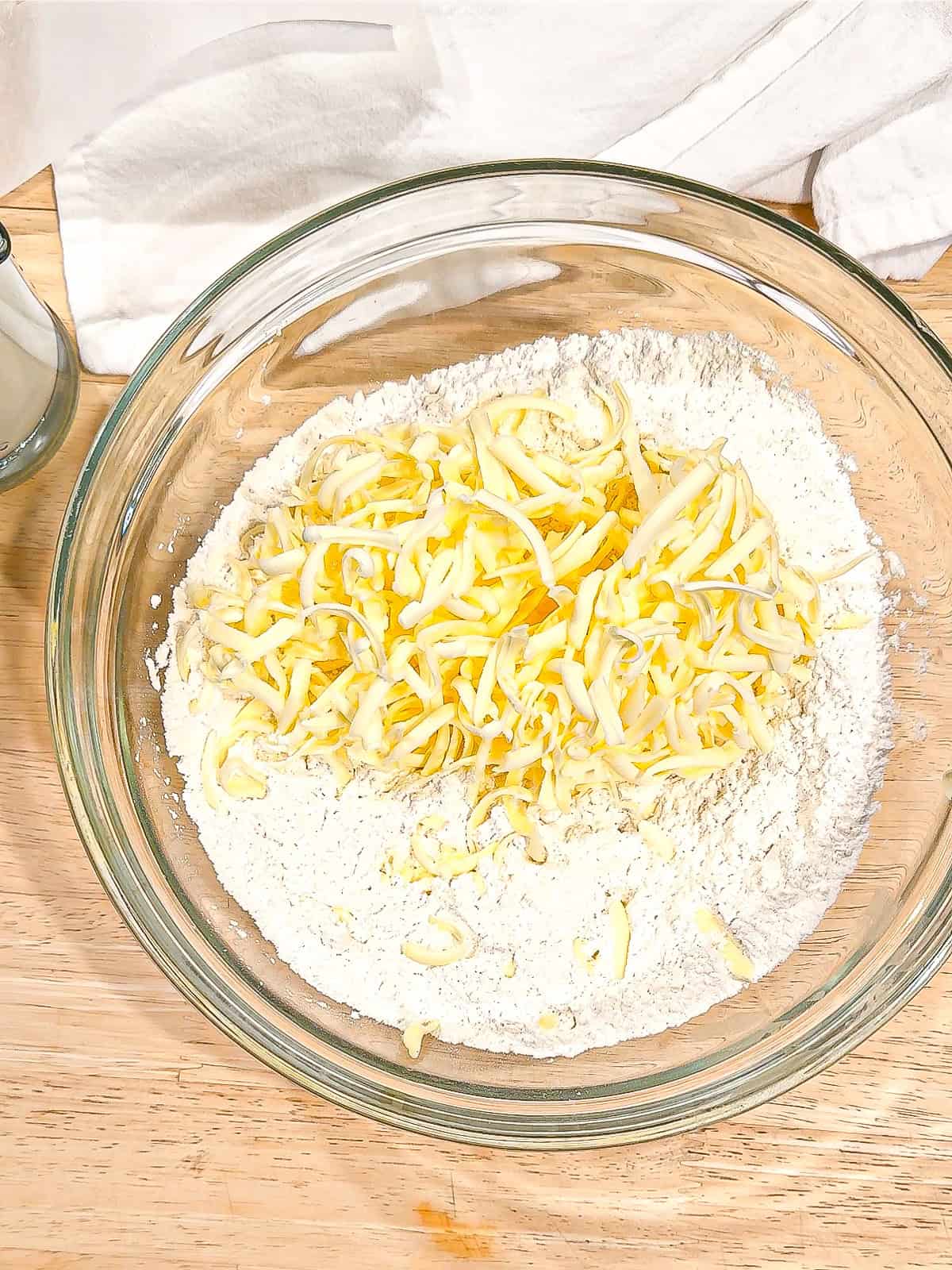 Grated butter and flour in a glass bowl.