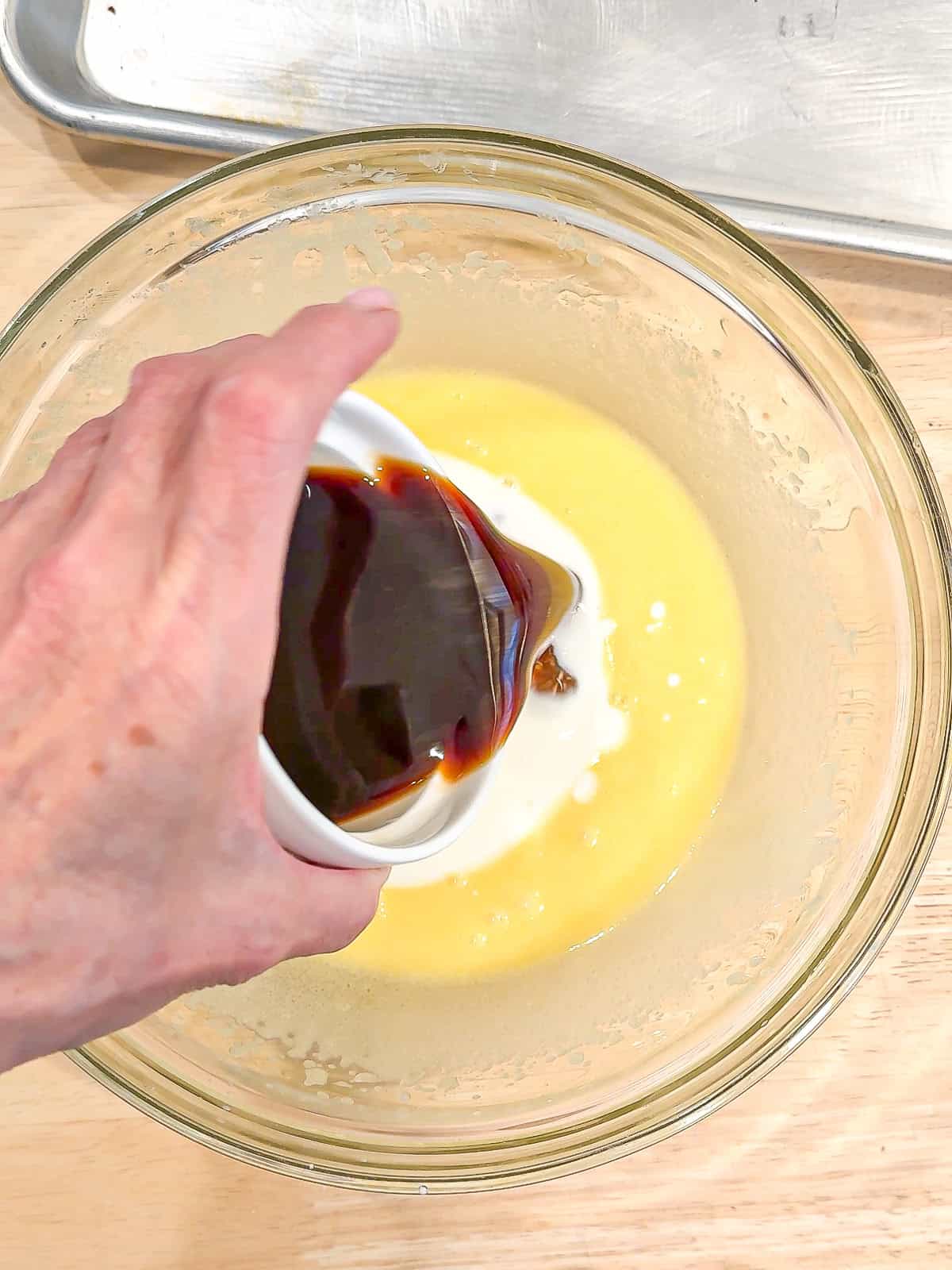 Adding hot coffee to wet ingredients to make chocolate cake.
