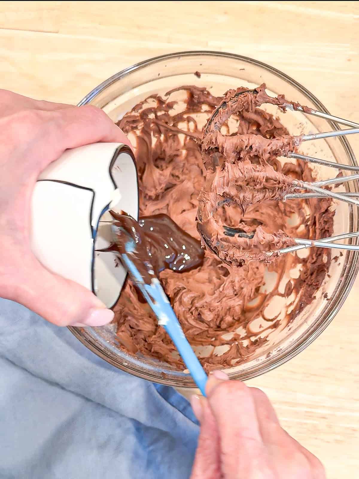 Adding melted chocolate to chocolate buttercream.