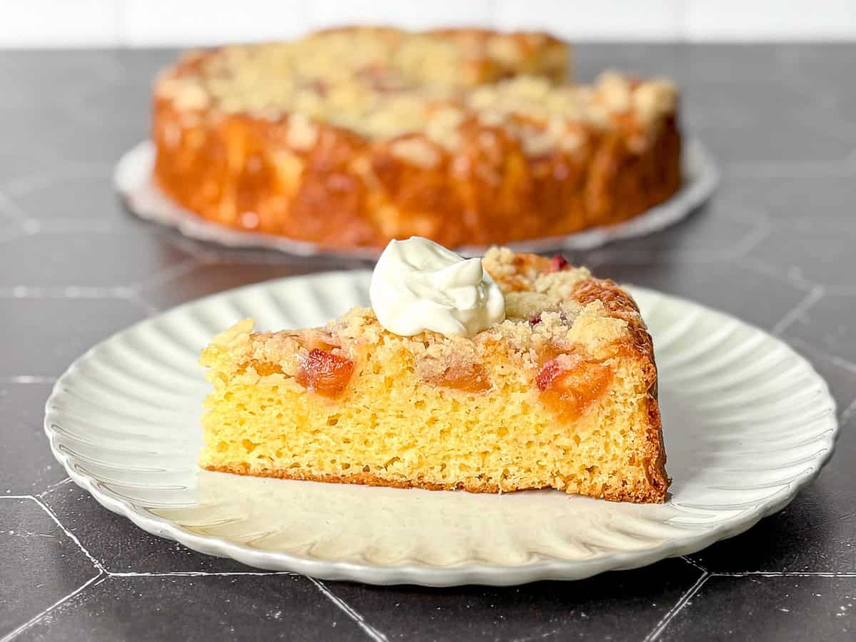 French yogurt cake with brown sugar peaches on a black background.