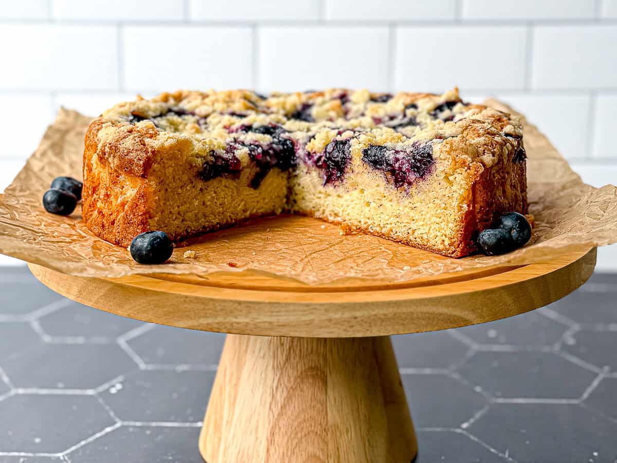 Side view of a French yogurt cake on a wooden pedestal.