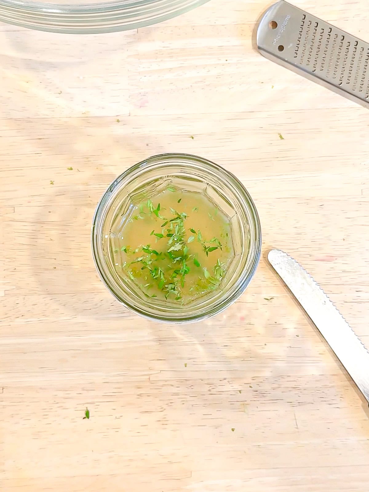 Honey, lime juice, lime zest, and fresh thyme in a glass jar.