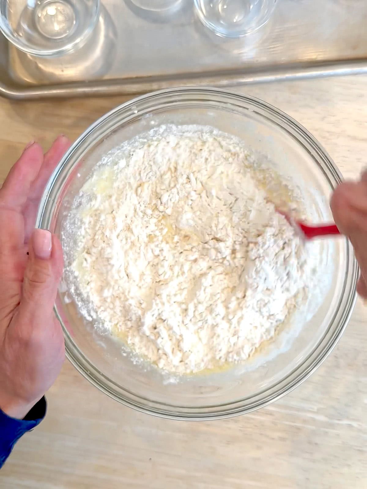Mixing dry ingredients into wet ingredients to make donut batter.