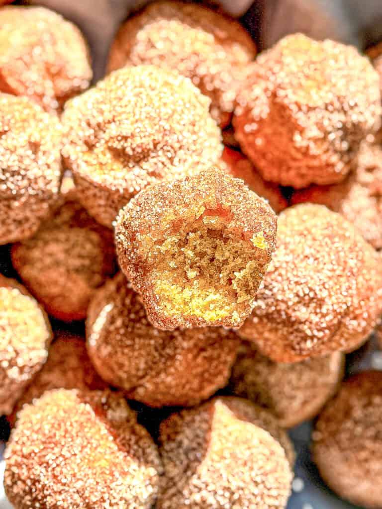 A pile of mini muffins covered in cinnamon sugar.