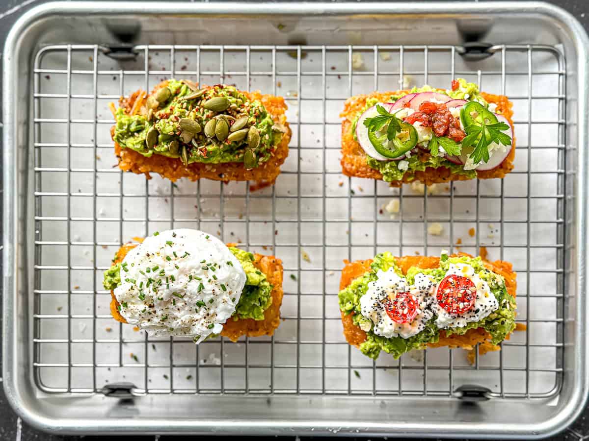 Various hash brown avocado toast on a wire rack.