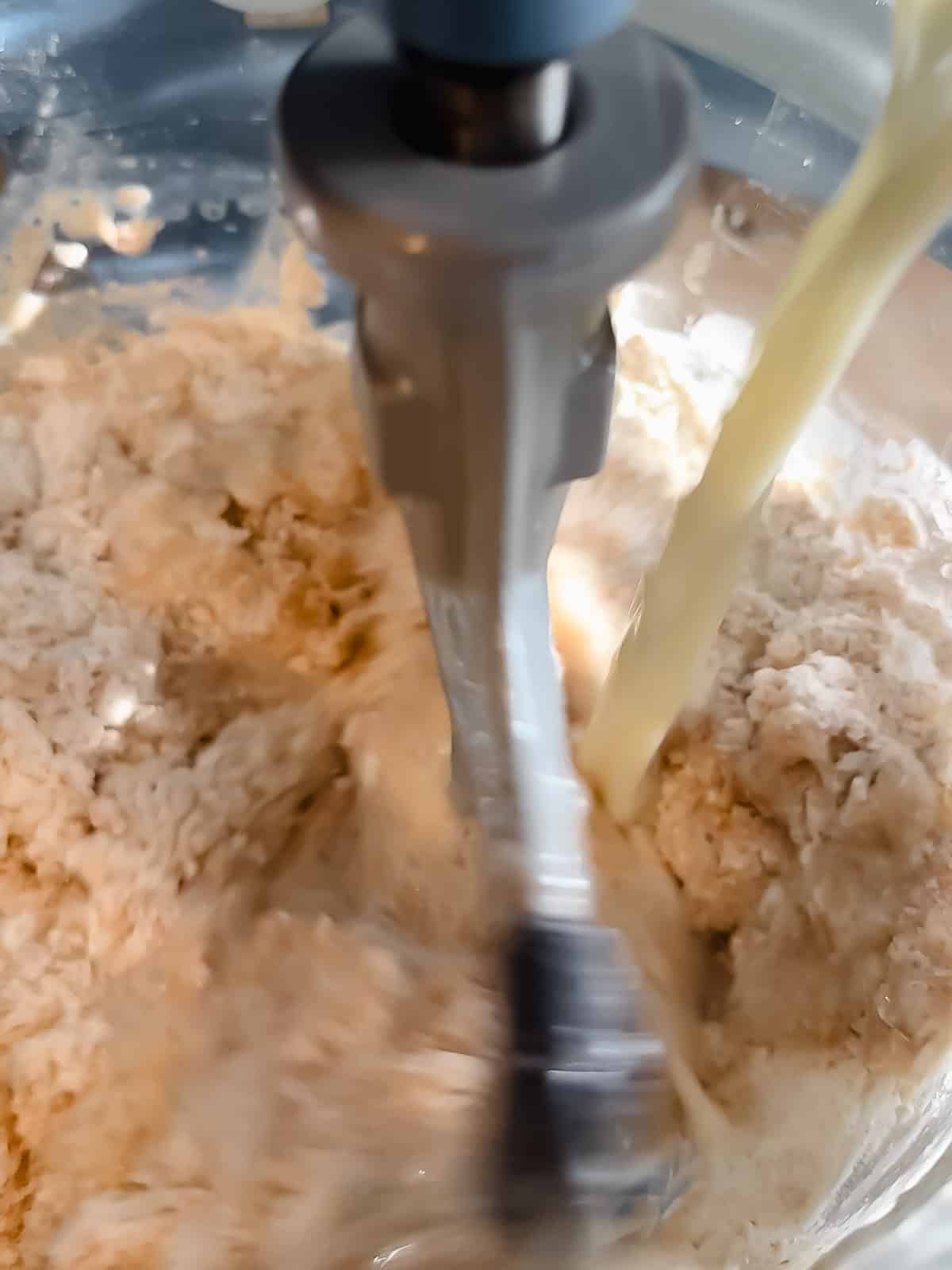 Adding wet ingredients into flour mixture to form honey wheat bread dough.