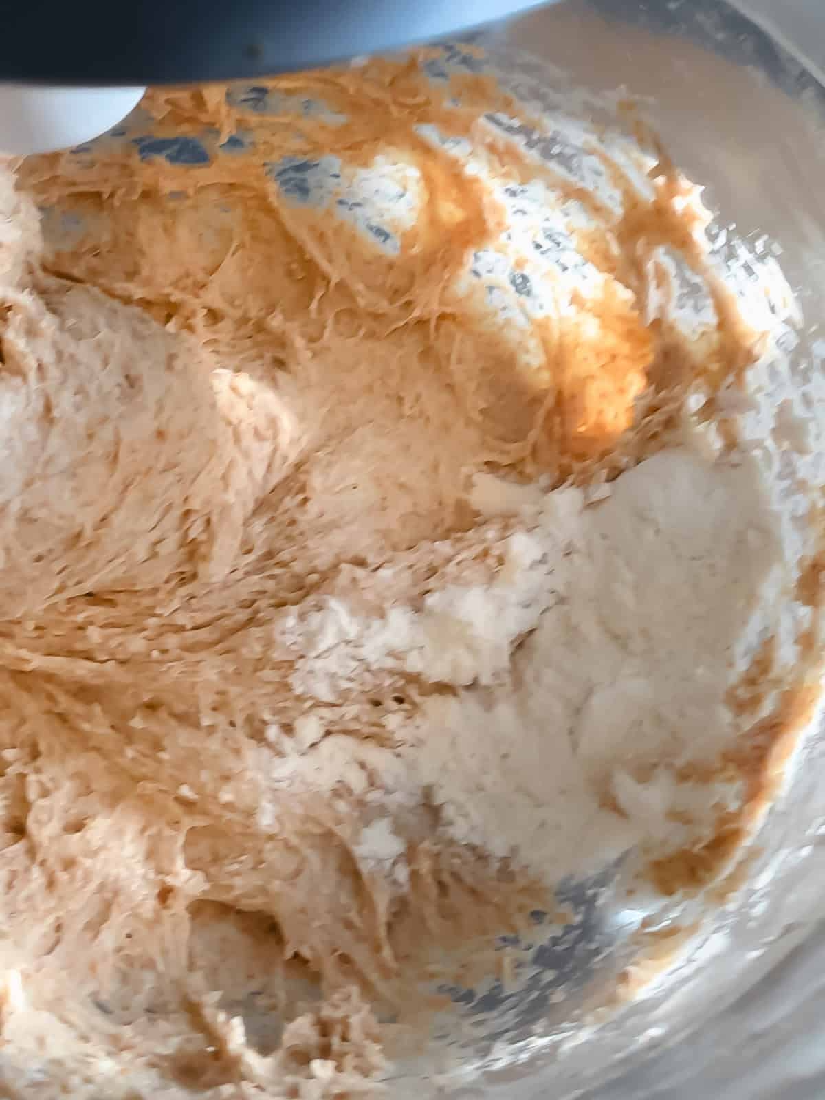 Adding a tablespoon of flour too honey wheat dough and a stand mixer bowl.