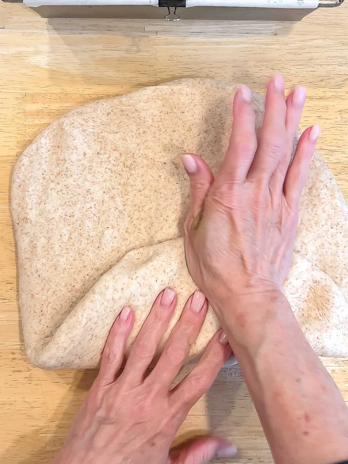 Forming a loaf of honey wheat bread.