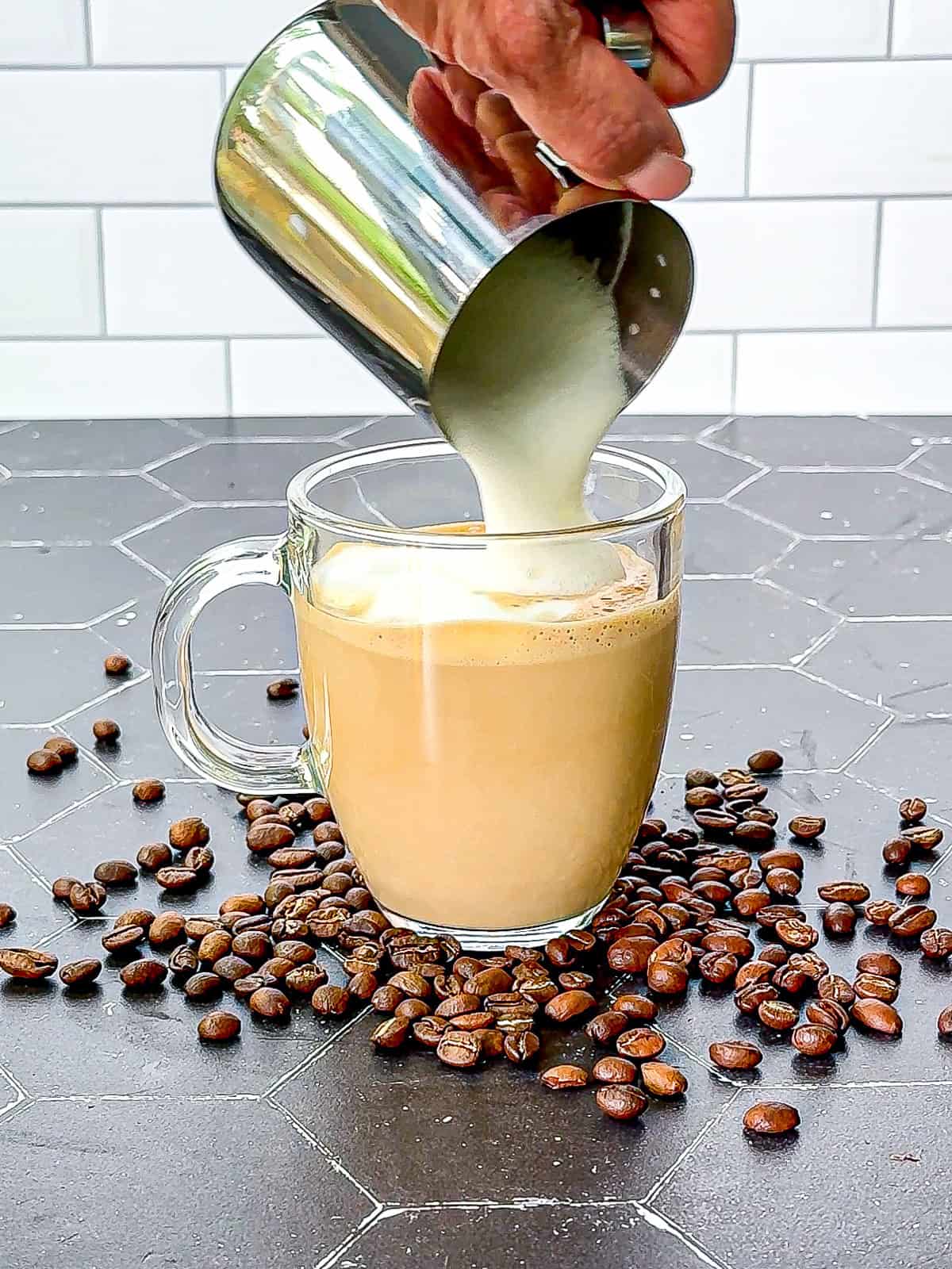 Pouring foam on top of a vanilla latte.