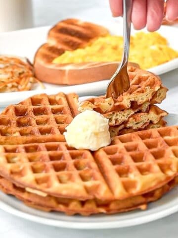 Waffle house waffle waffles on a white plate with more breakfast in the background.