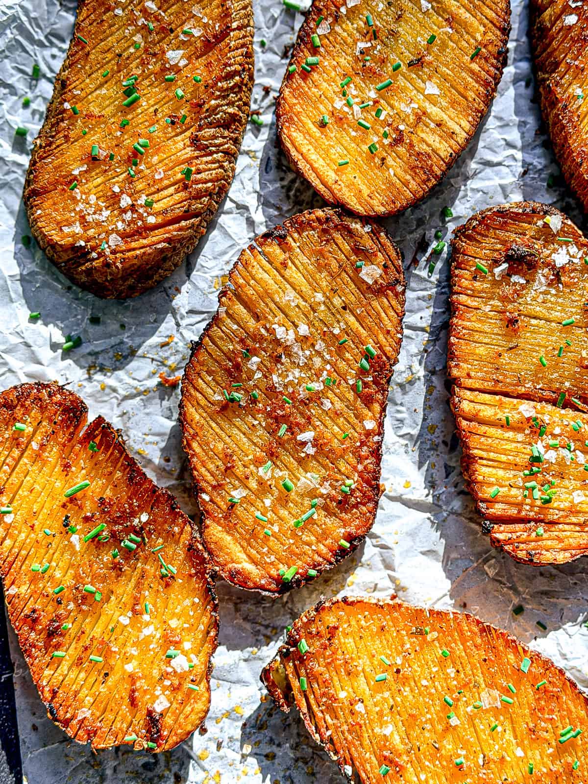 Crispy accordion potatoes on parchment paper.