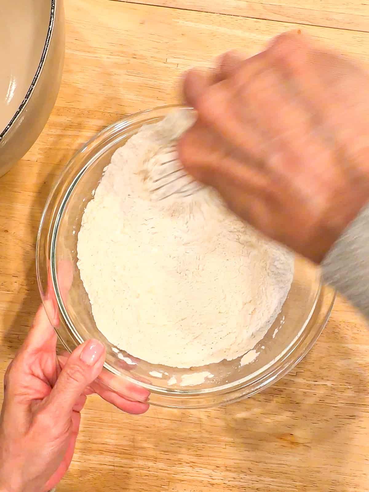 Mixing dry ingredients in a glass bowl.