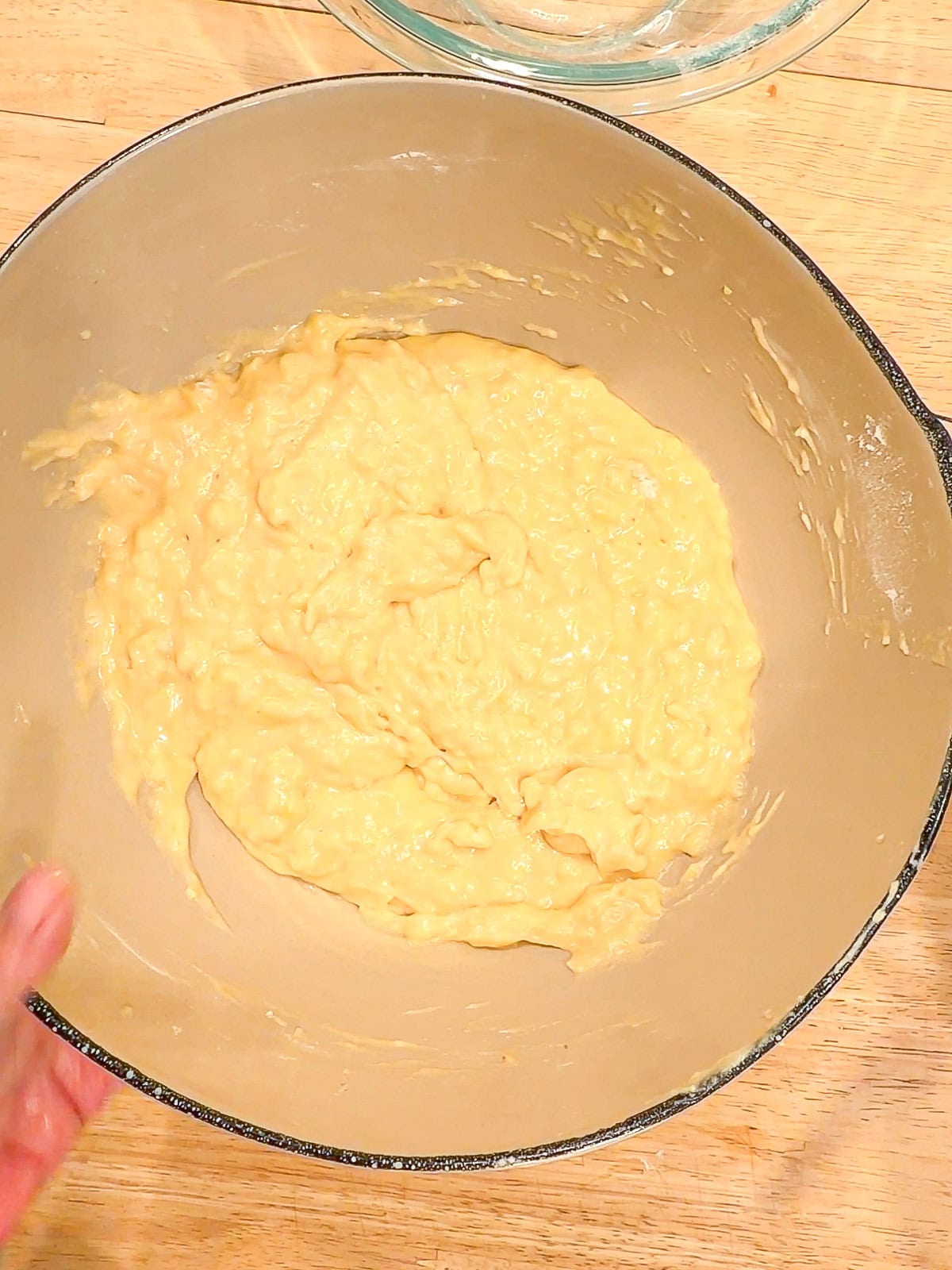 Muffin batter in a tan bowl.