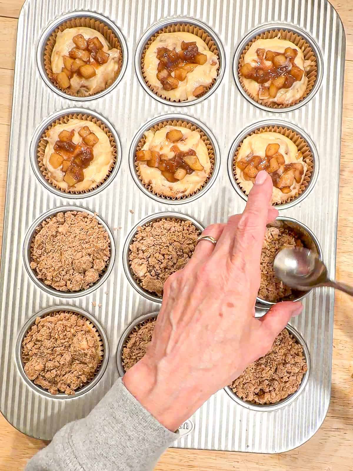 Adding streusel topping to muffins.