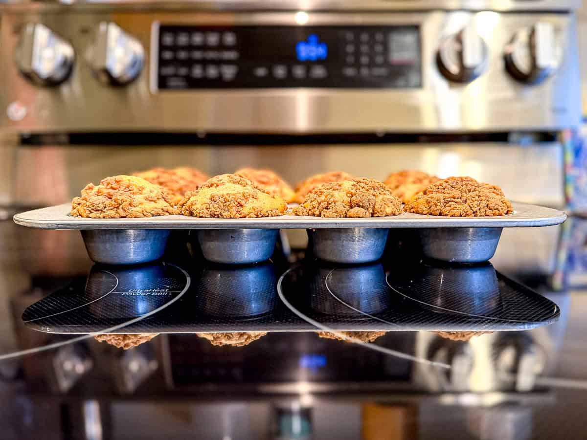 Side view of apple pie muffins in a muffin 10 showing their tall round tops.