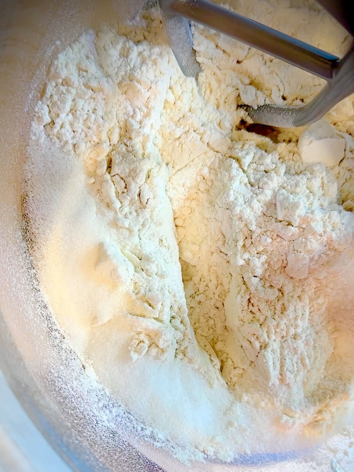 Whisking dry ingredients to make brioche dough in a stand mixer.