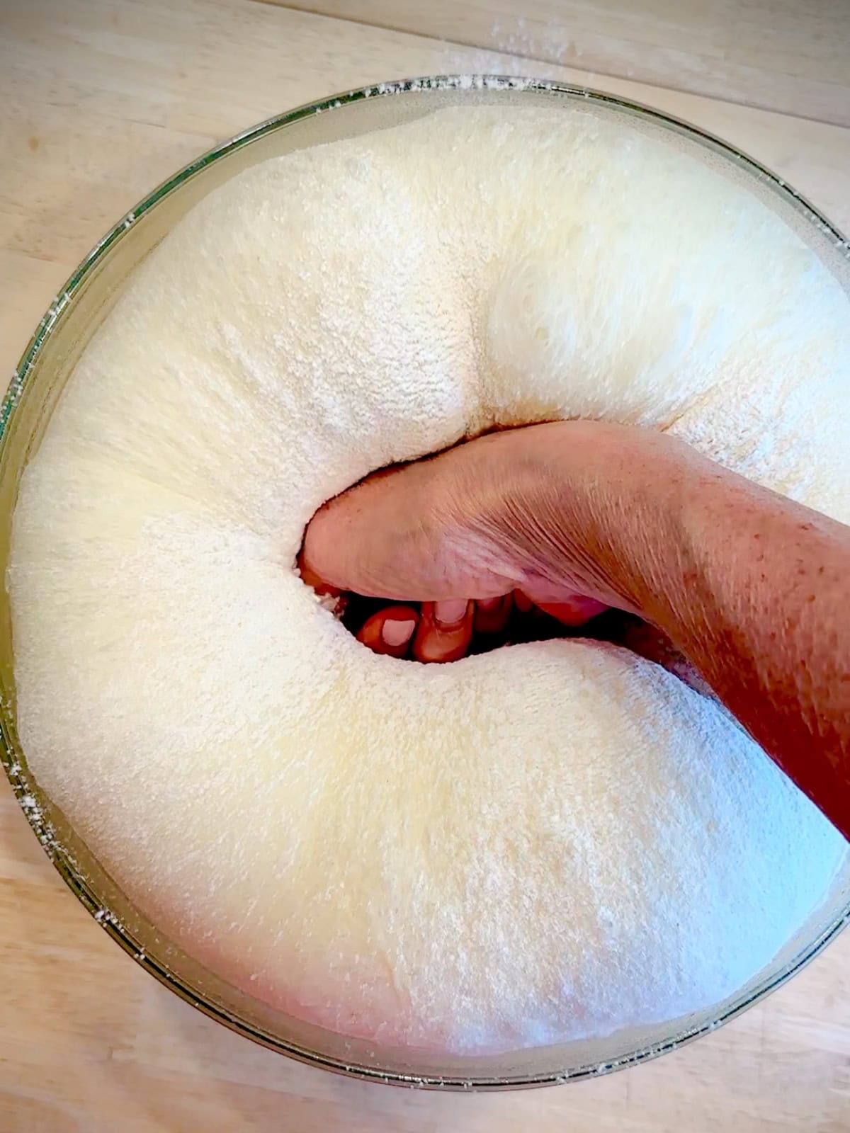 Punching down fully risen brioche dough.