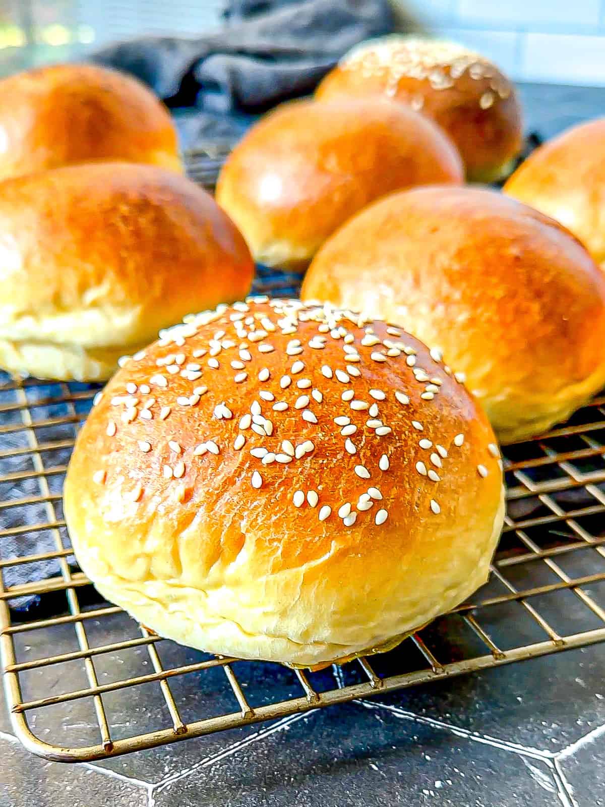 Brioche buns on a wire rack.
