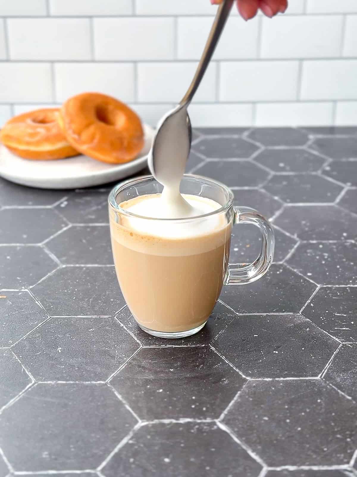 Adding foam to a donut latte.