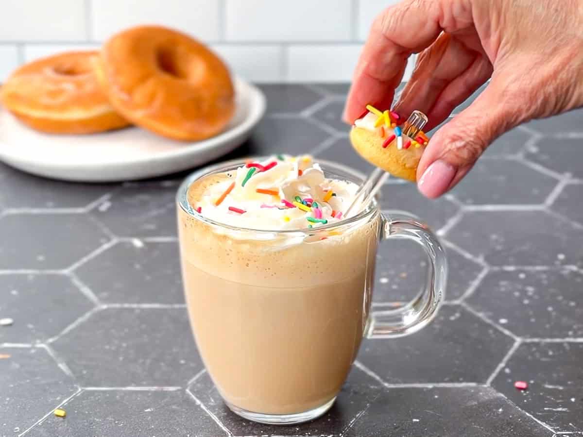 Garnishing donut latte with a mini donut.