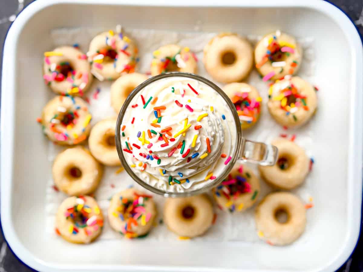 Glazed donut latte with whipped cream and sprinkles.