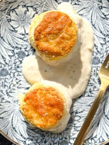 Biscuits and gravy on a floral plate.