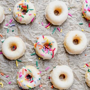 Baked glazed mini donuts on parchment paper.