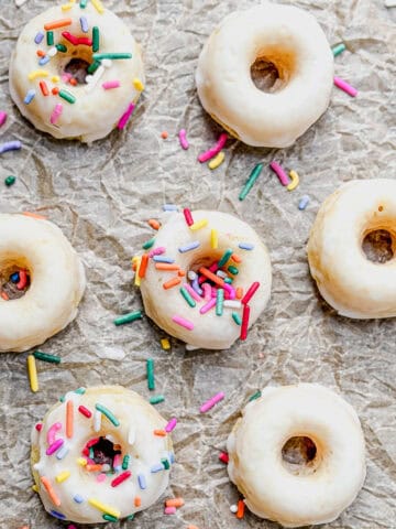 Baked glazed mini donuts on parchment paper.