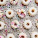 Baked glazed mini donuts on parchment paper.