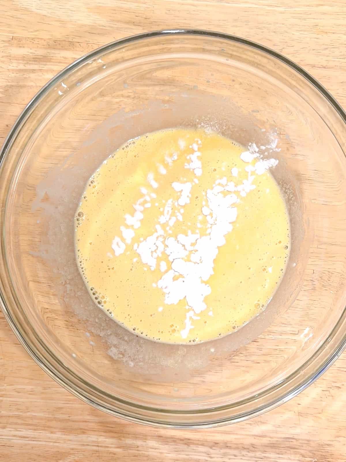 Adding baking powder, baking soda, and salt to wet ingredients.