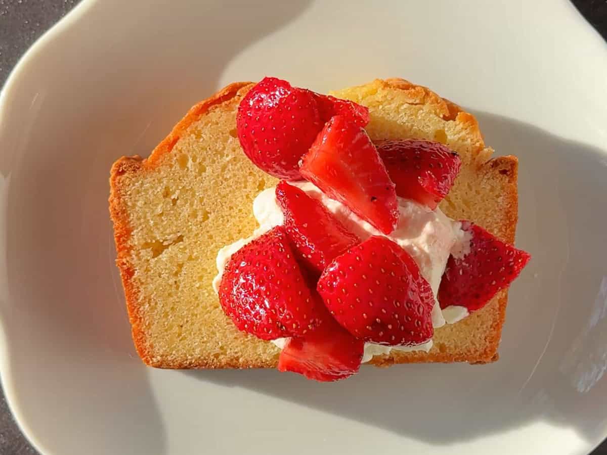 A slice of pound cake with whipped cream and berries.