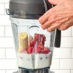 Placing the lid on a blender before making a strawberry banana smoothie.