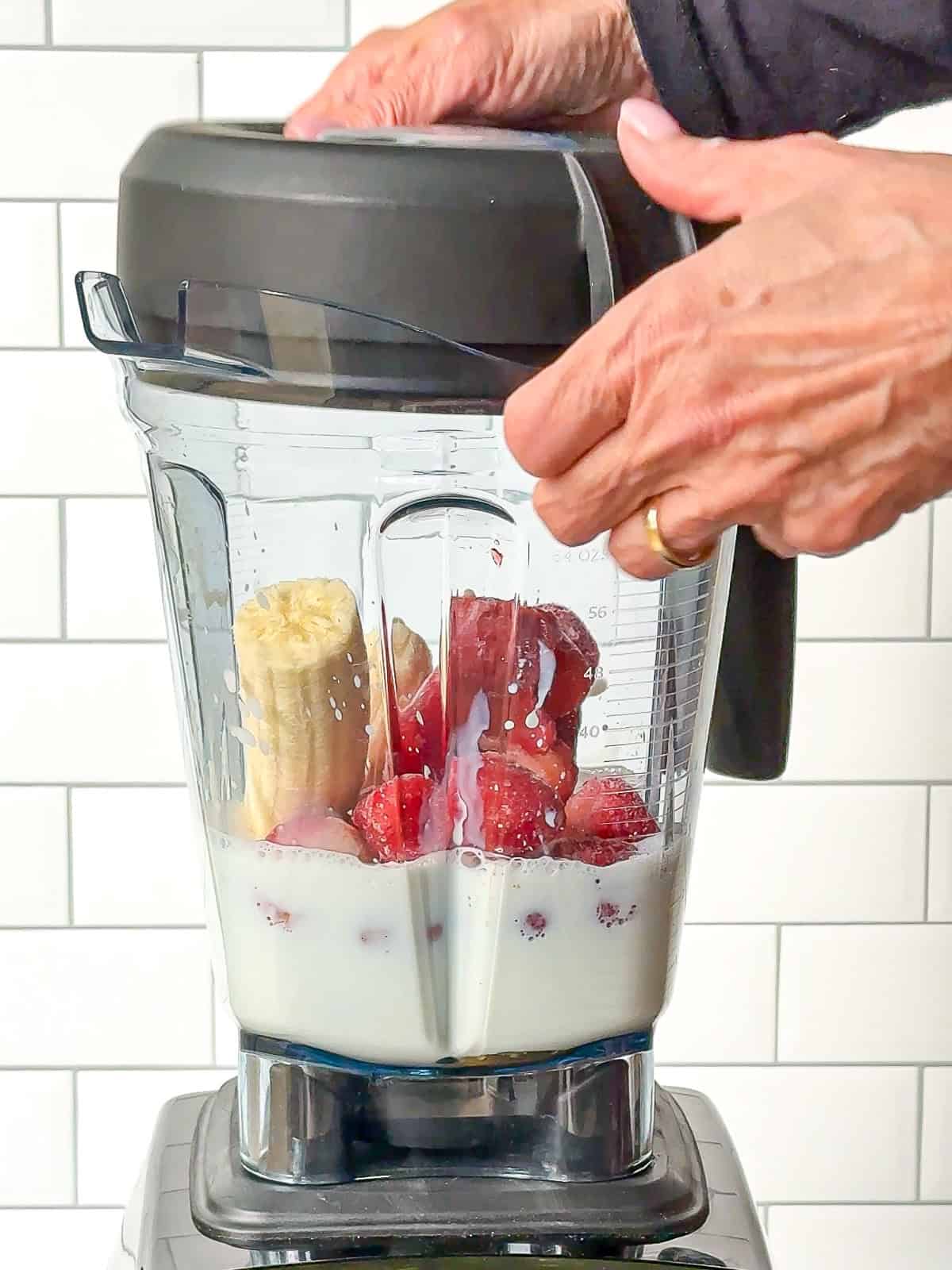 Placing the lid on a blender before making a strawberry banana smoothie.