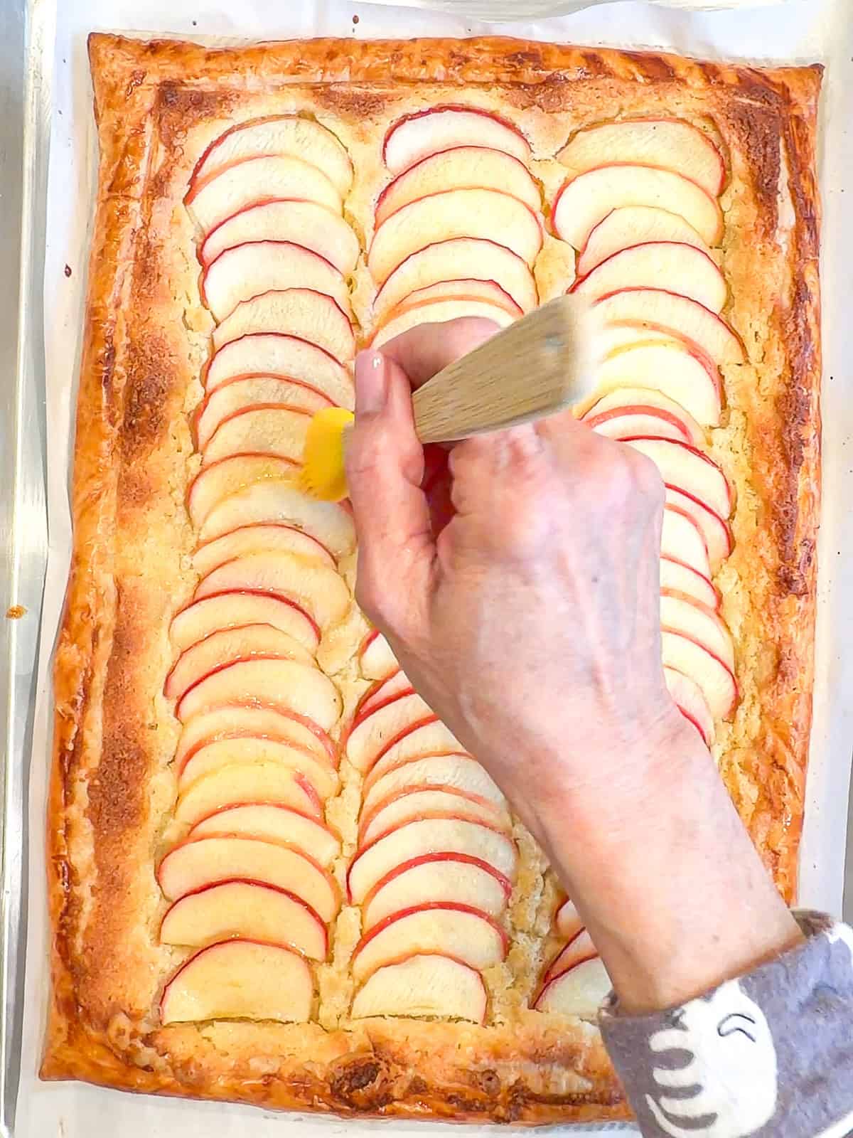 Brushing warm honey on Apple frangipane tart.
