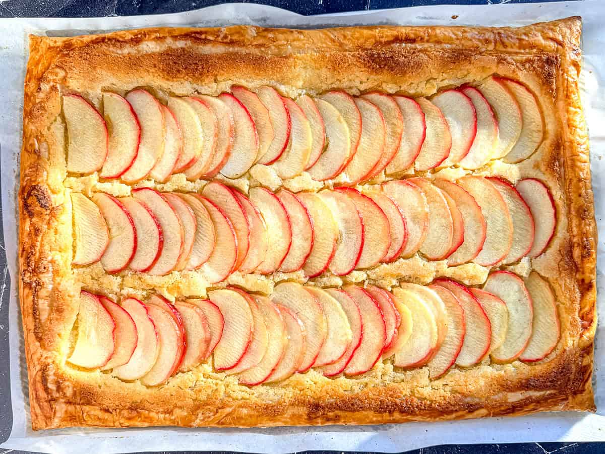 Apple frangipane tart on parchment paper.