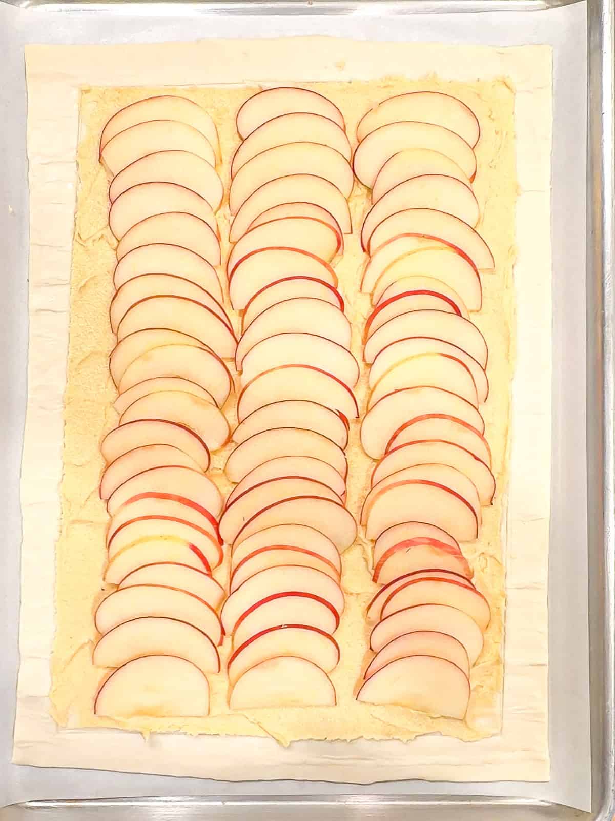 Three rows of apple slices on frangipane to make tart.