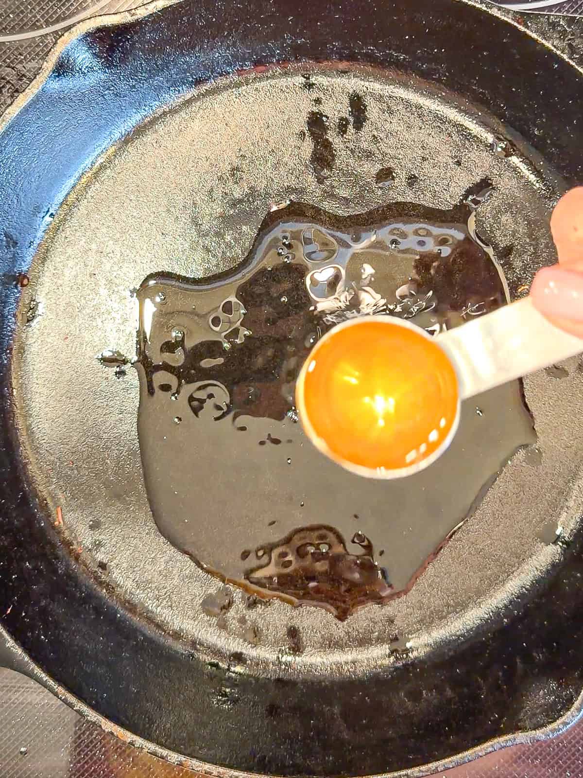 Adding baking grease to a cast-iron pan.