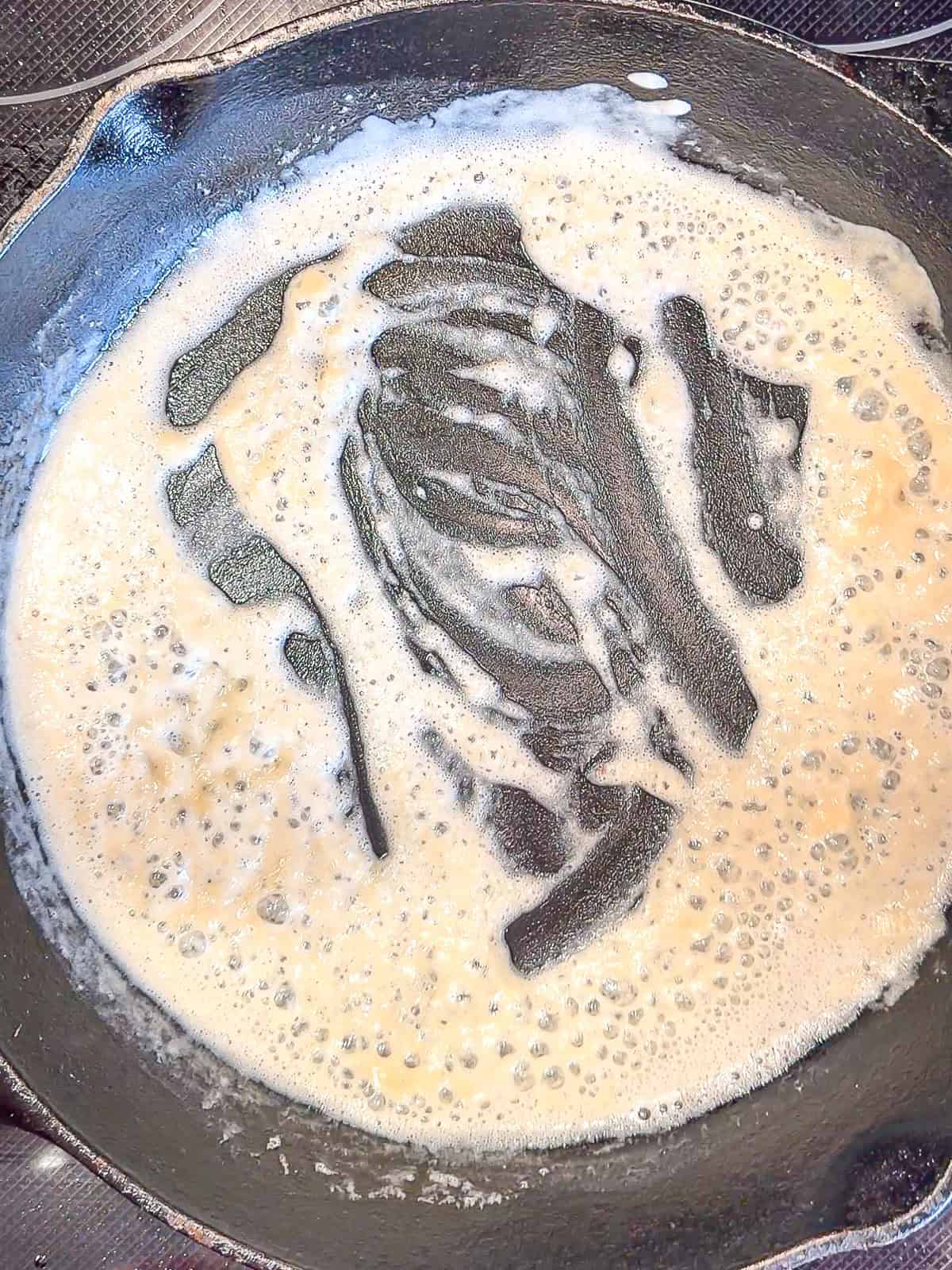 Butter and flour cooking in a cast-iron pan.