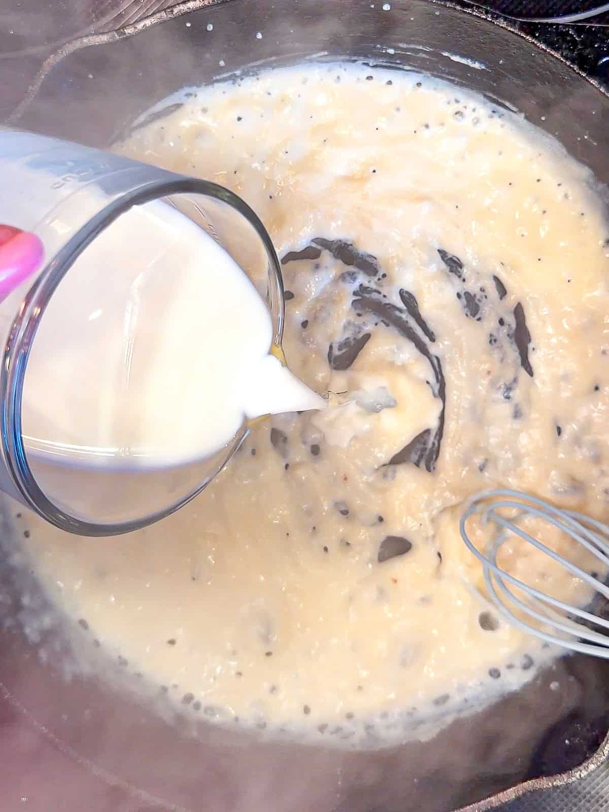 Pouring milk into gravy.