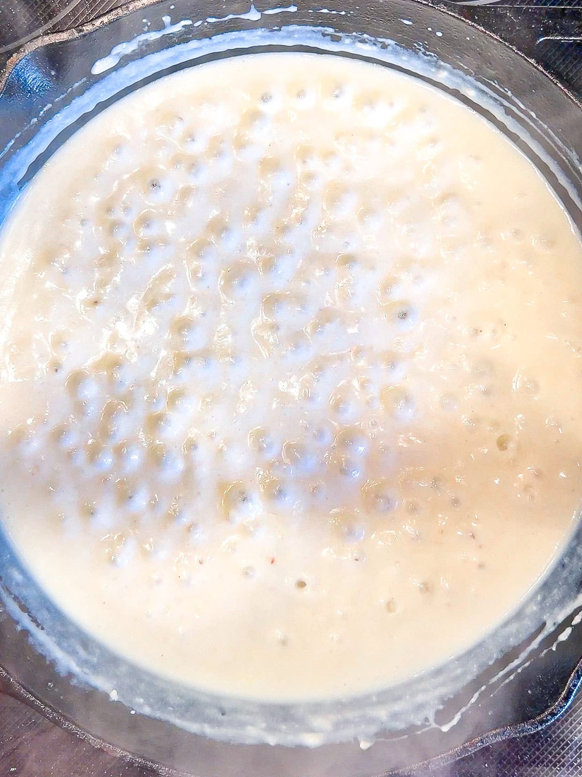 Gravy bubbling in a cast-iron pan.